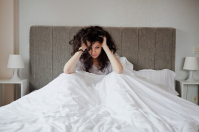 Woman having a depression in her bed looking sad