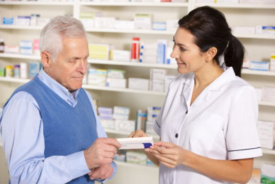 pharmacist serving senior man in pharmacy